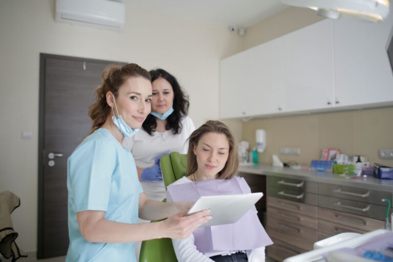 Dental professional reviewing information on a tablet with a patient during a consultation